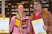 Zwei Personen zeigen Bücher in die Kamera