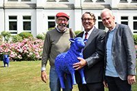 Drei Männer vor einem Haus